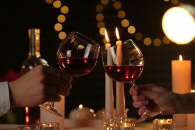 Photo of Couple clinking glasses of wine in restaurant, closeup. Romantic dinner