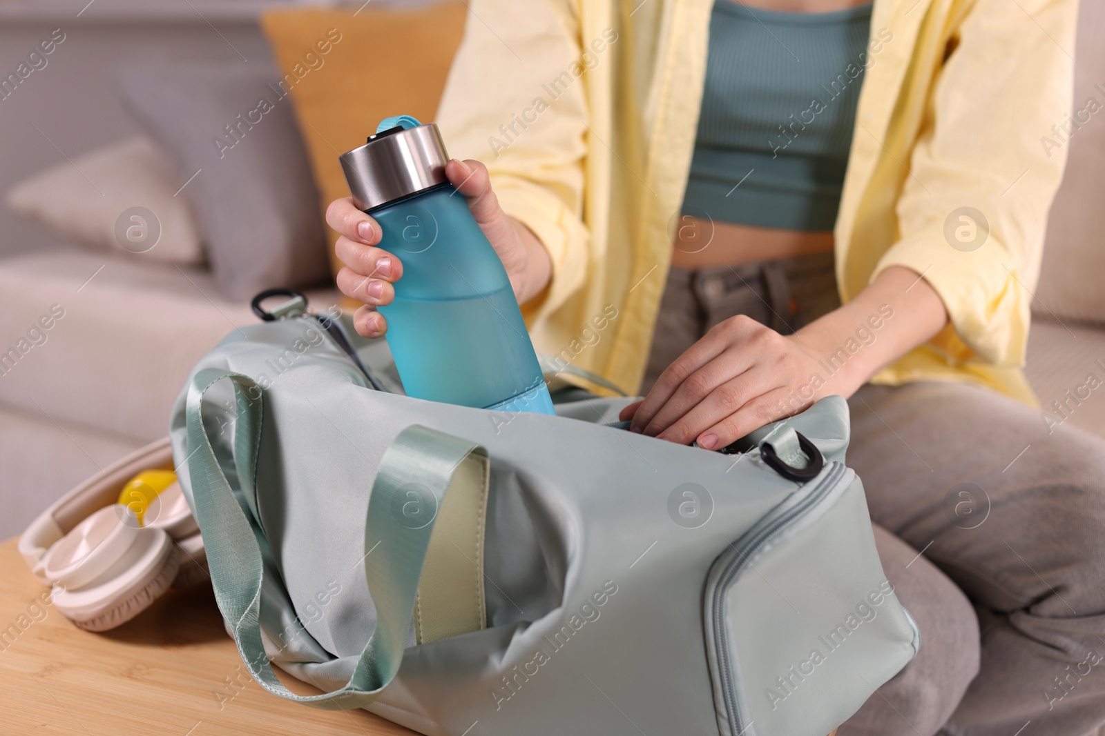 Photo of Woman packing her gym bag at home, closeup