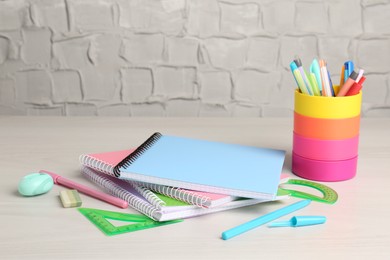 Photo of Doing homework. Notebooks and other different stationery on wooden table, closeup