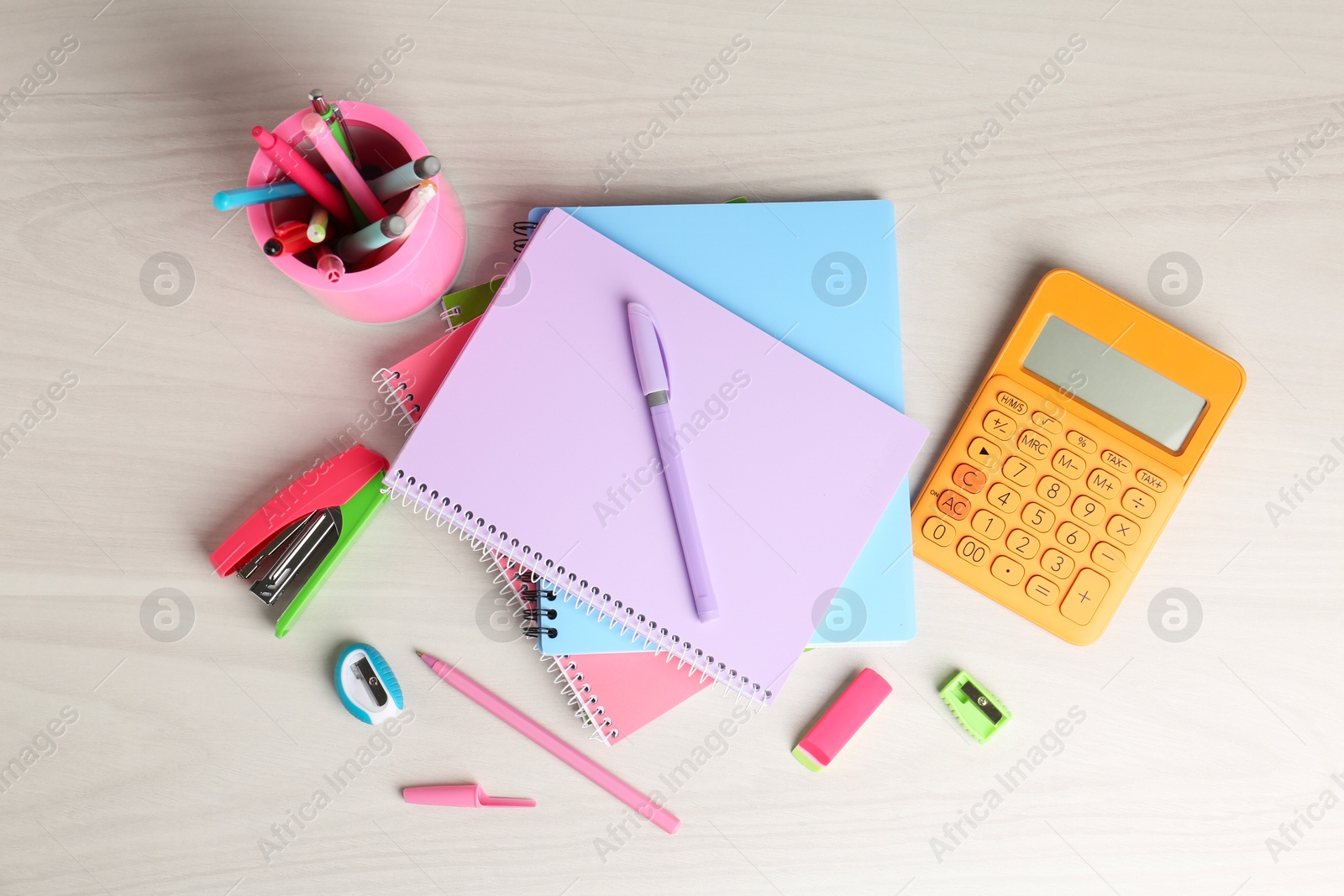 Photo of Doing homework. Notebooks and other different stationery on wooden table, flat lay