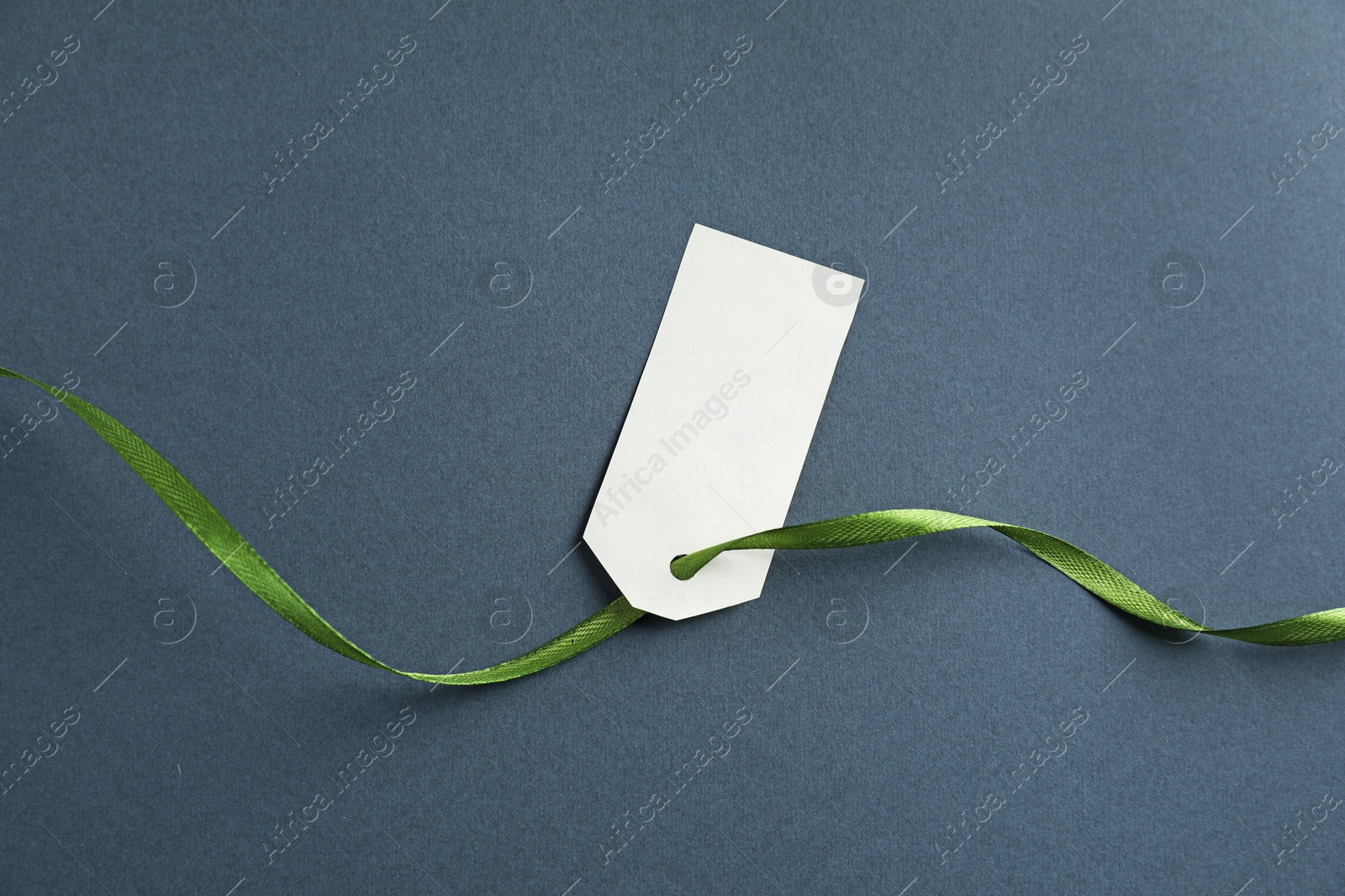 Blank tag with ribbon on grey background, top view Photo of Blank tag with ribbon on grey background, top view
