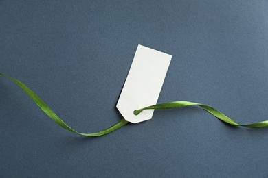 Photo of Blank tag with ribbon on grey background, top view