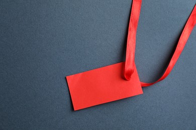 Photo of Blank tag with ribbon on grey background, top view