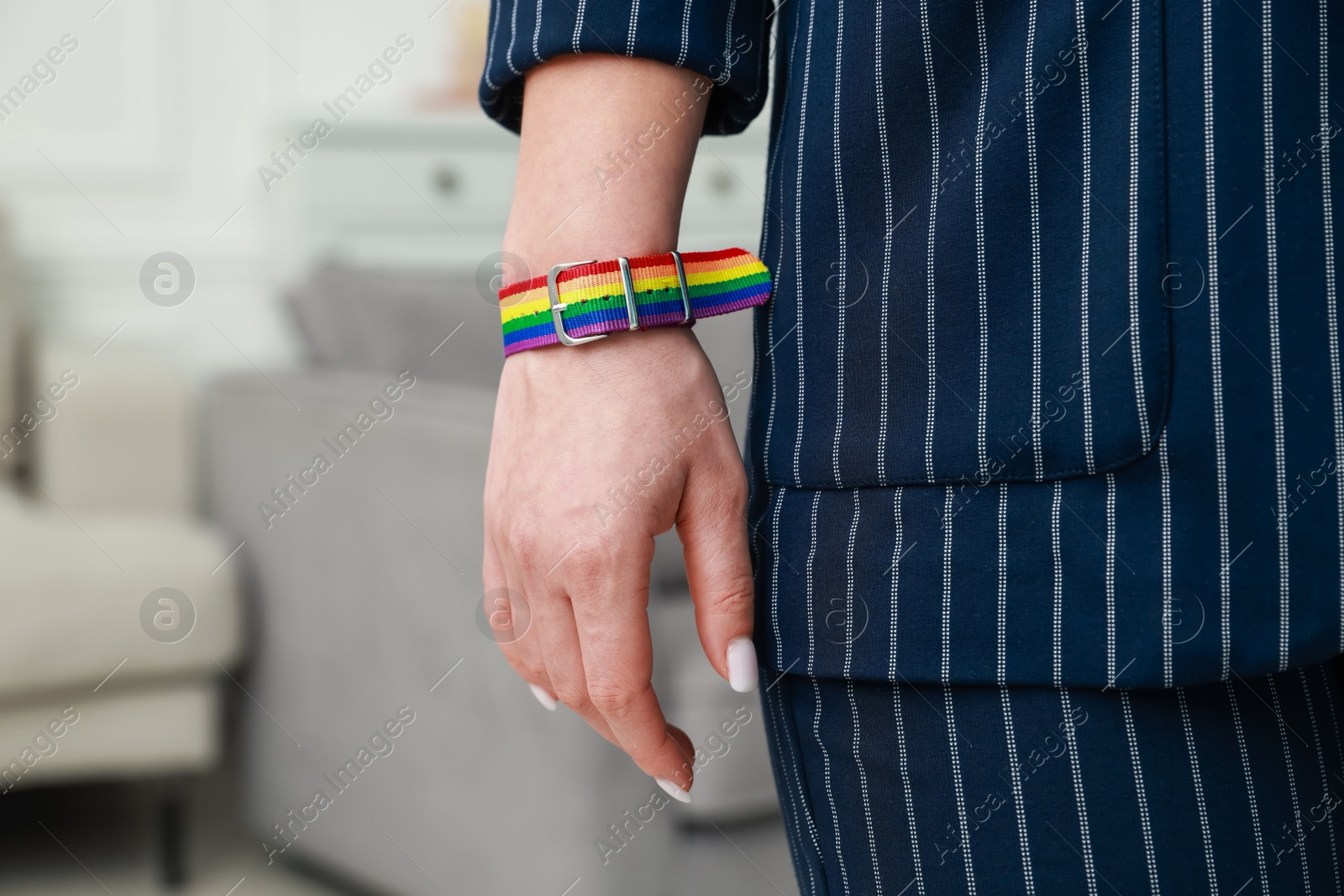 Photo of Woman wearing wristband in LGBT colors indoors, closeup. Space for text