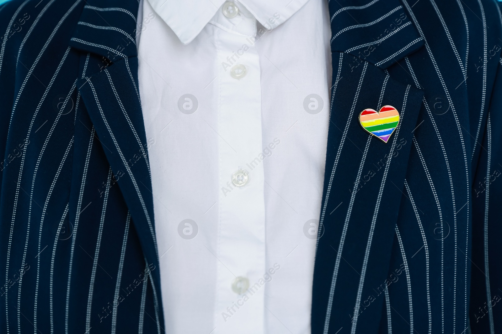 Photo of Woman with heart shaped pin in LGBT colors, closeup