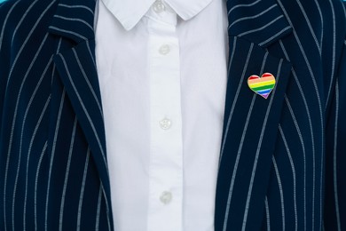 Photo of Woman with heart shaped pin in LGBT colors, closeup