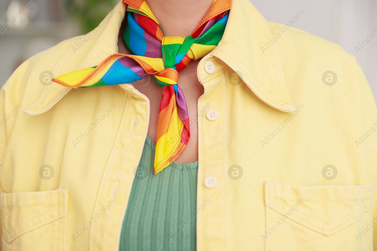 Photo of Woman wearing neckerchief in LGBT colors indoors, closeup