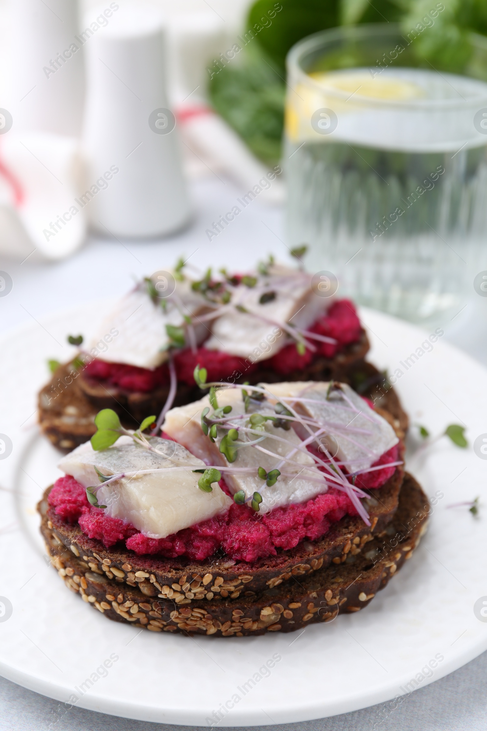 Photo of Tasty sandwiches with herring and horseradish sauce on table, closeup