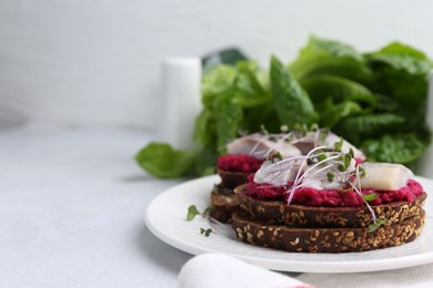 Photo of Tasty sandwiches with herring and horseradish sauce on light table, closeup. Space for text