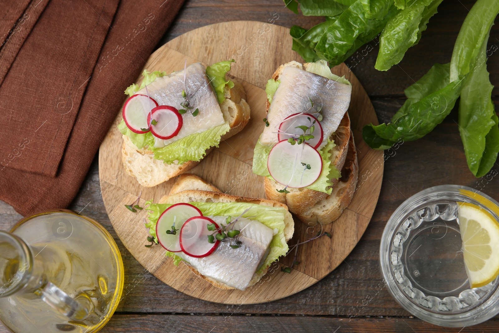 Tasty sandwiches with herring served on wooden table, flat lay Photo of Tasty sandwiches with herring served on wooden table, flat lay