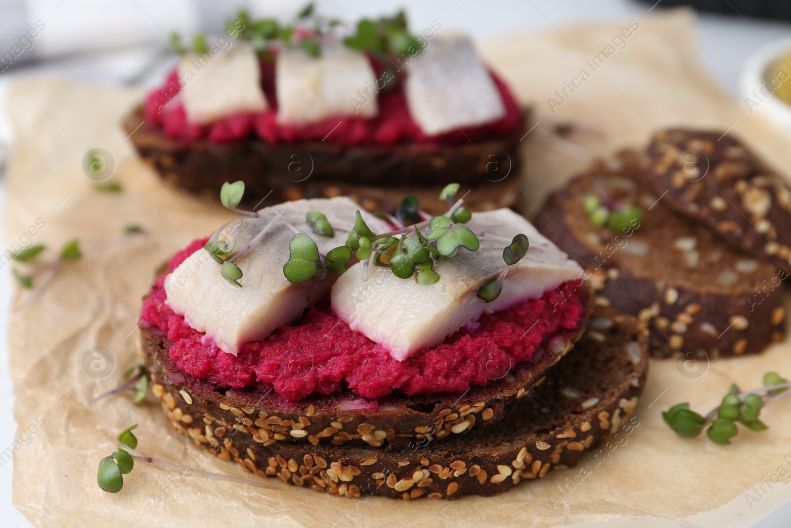 Photo of Tasty sandwiches with herring and horseradish sauce on table, closeup