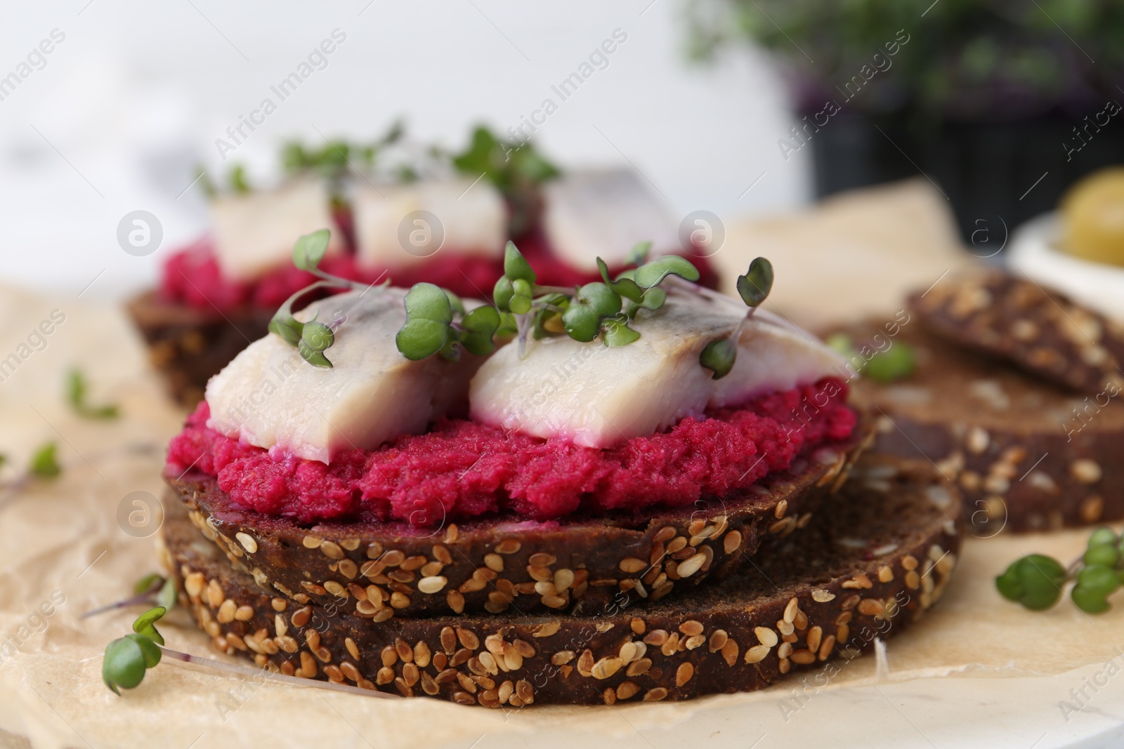 Photo of Tasty sandwiches with herring and horseradish sauce on table, closeup