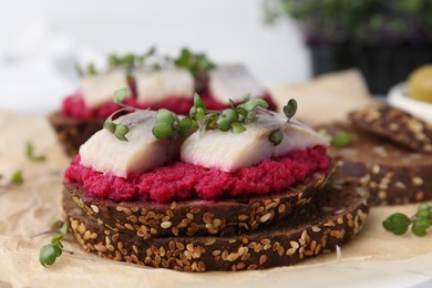 Tasty sandwiches with herring and horseradish sauce on table, closeup