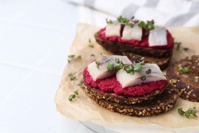 Photo of Tasty sandwiches with herring and horseradish sauce on white table, closeup. Space for text