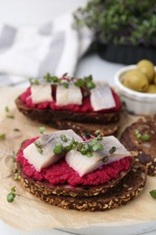 Photo of Tasty sandwiches with herring and horseradish sauce on table, closeup