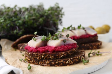 Photo of Tasty sandwiches with herring and horseradish sauce on table, closeup