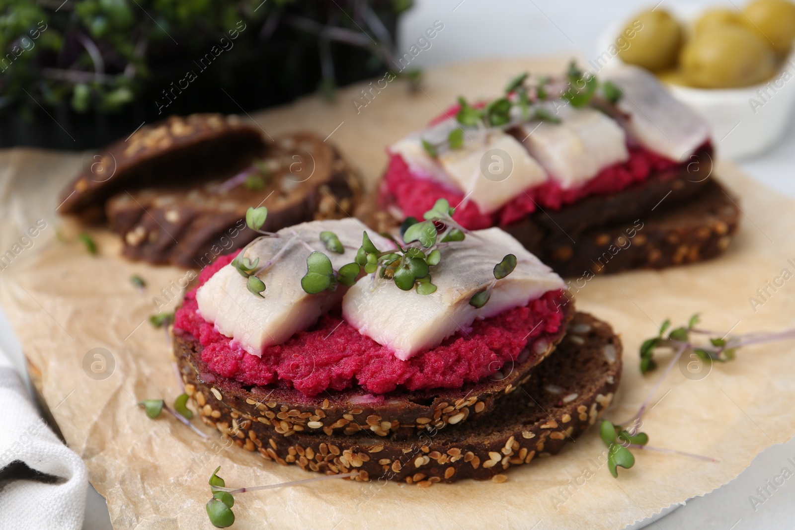 Photo of Tasty sandwiches with herring and horseradish sauce on table, closeup