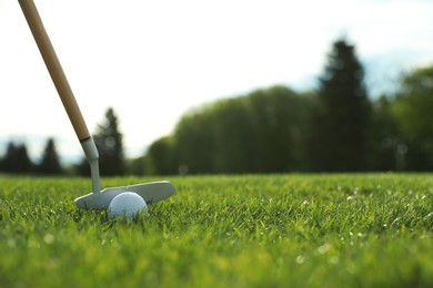 Photo of Hitting golf ball with club on green course, space for text