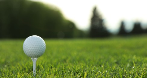 Photo of Golf ball on tee at green course, space for text