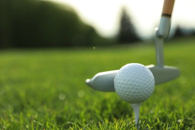 Photo of Hitting golf ball with club on green course, closeup. Space for text