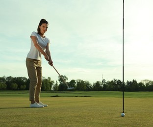 Photo of Beautiful woman playing golf on green course