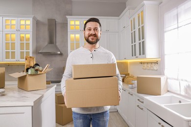 Photo of Moving day. Man with cardboard boxes in his new home