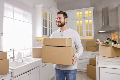 Moving day. Man with cardboard boxes in his new home