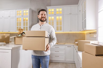 Photo of Moving day. Man with cardboard boxes in his new home