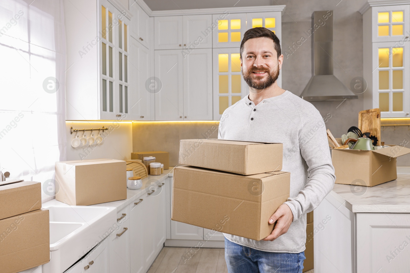 Photo of Moving day. Man with cardboard boxes in his new home