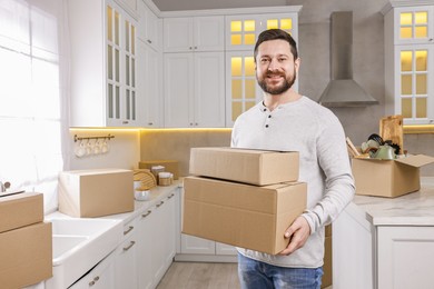 Moving day. Man with cardboard boxes in his new home