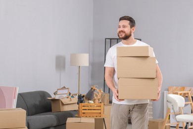 Photo of Moving day. Man with cardboard boxes in his new home