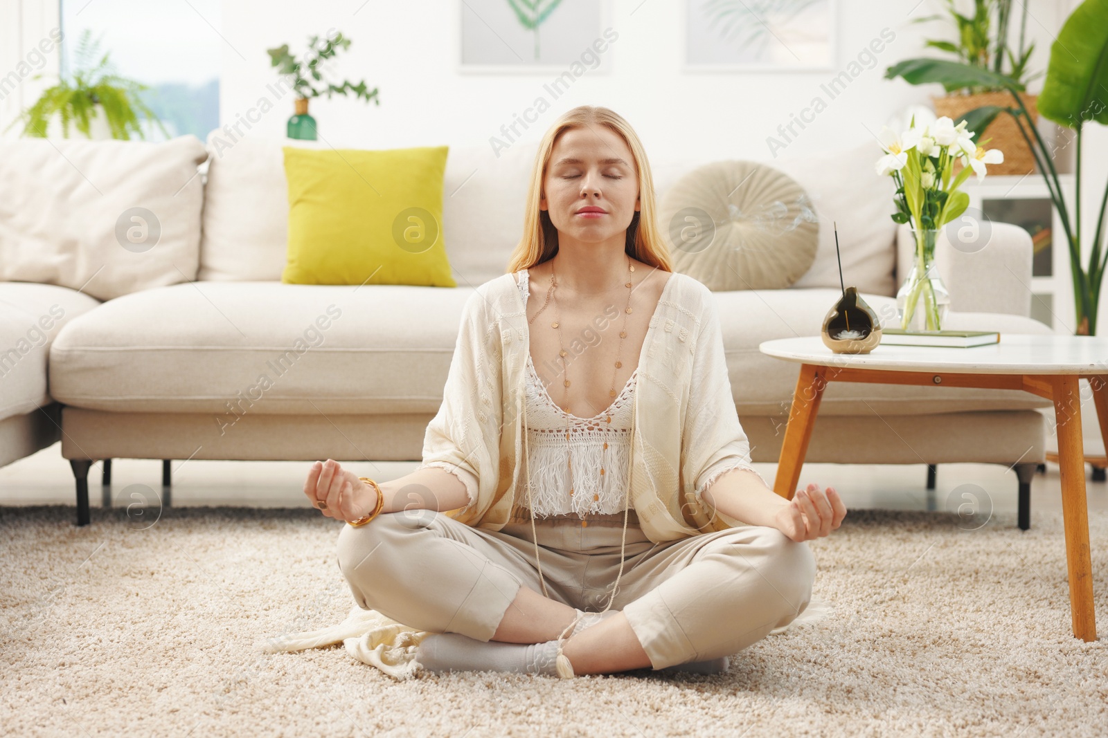 Photo of Feng shui. Young woman meditating on floor at home