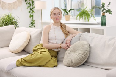 Photo of Feng shui. Young woman sitting on couch at home