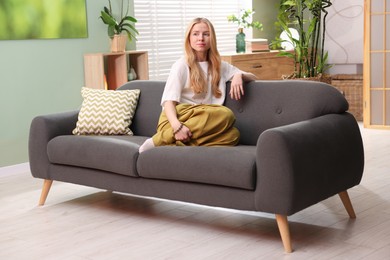 Photo of Feng shui. Young woman sitting on couch at home