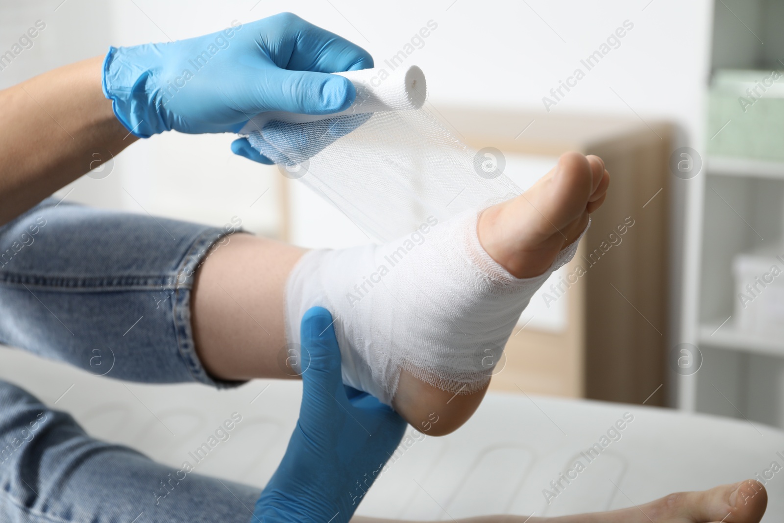 Photo of Doctor bandaging patient's foot in clinic, closeup