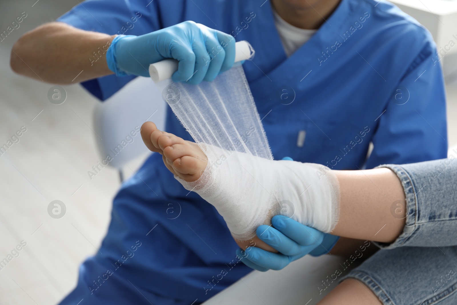 Photo of Doctor bandaging patient's foot in clinic, closeup