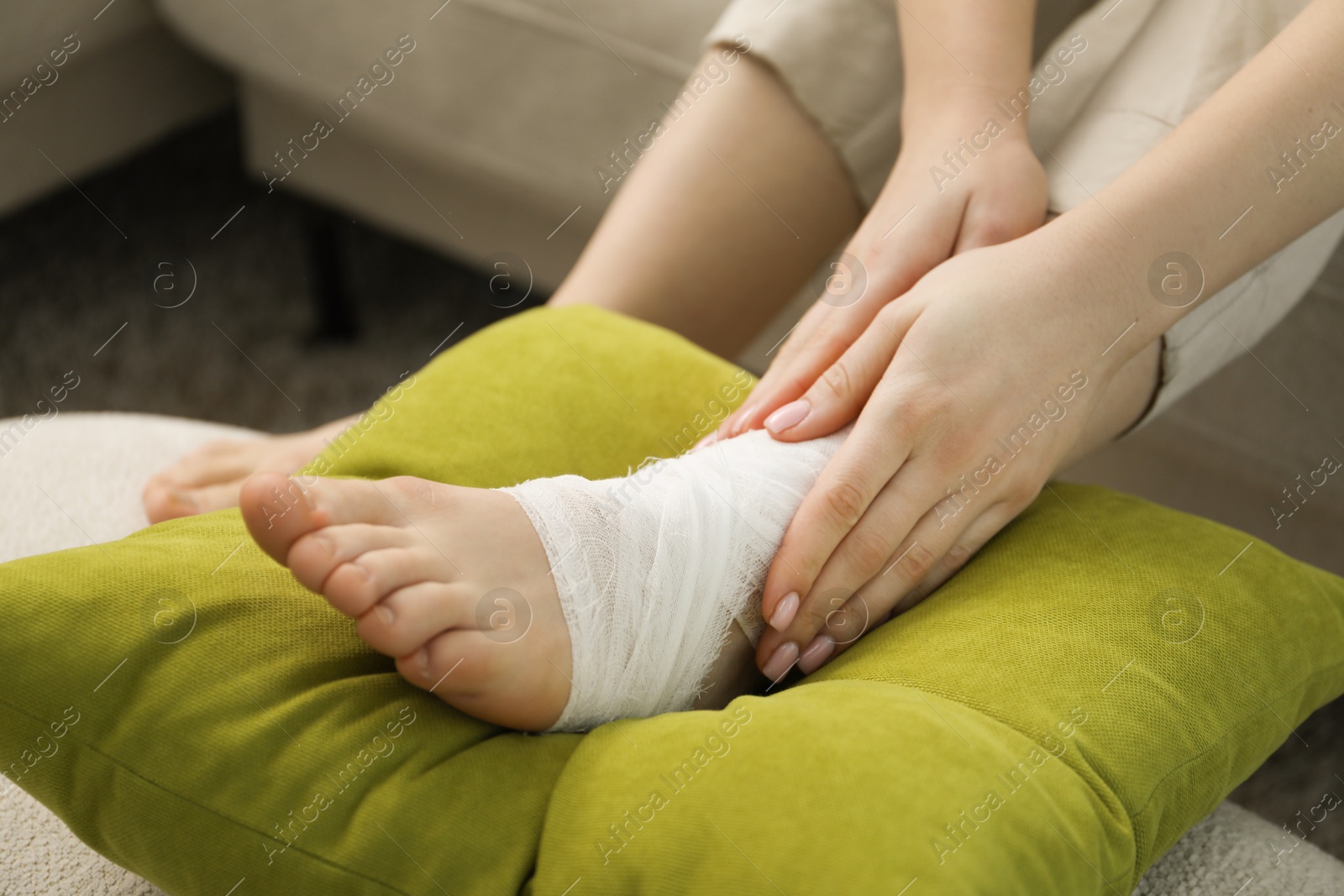 Photo of Woman with medical bandage on her foot at home, closeup