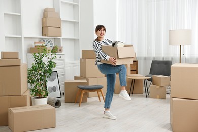 Photo of Moving day. Happy woman with her belongings in new home