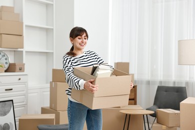 Photo of Moving day. Happy woman with her belongings in new home