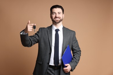 Photo of Cheerful salesman with car key and clipboard on beige background