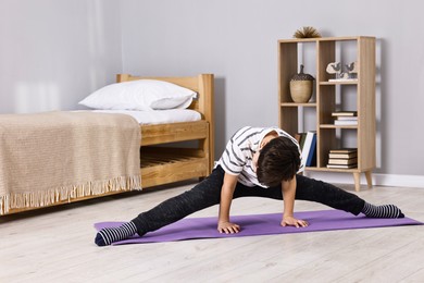 Photo of Little boy exercising at home. Morning routine