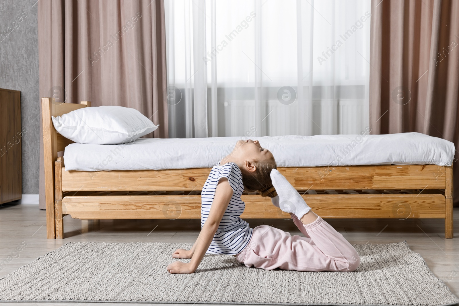 Photo of Little girl exercising at home. Morning routine