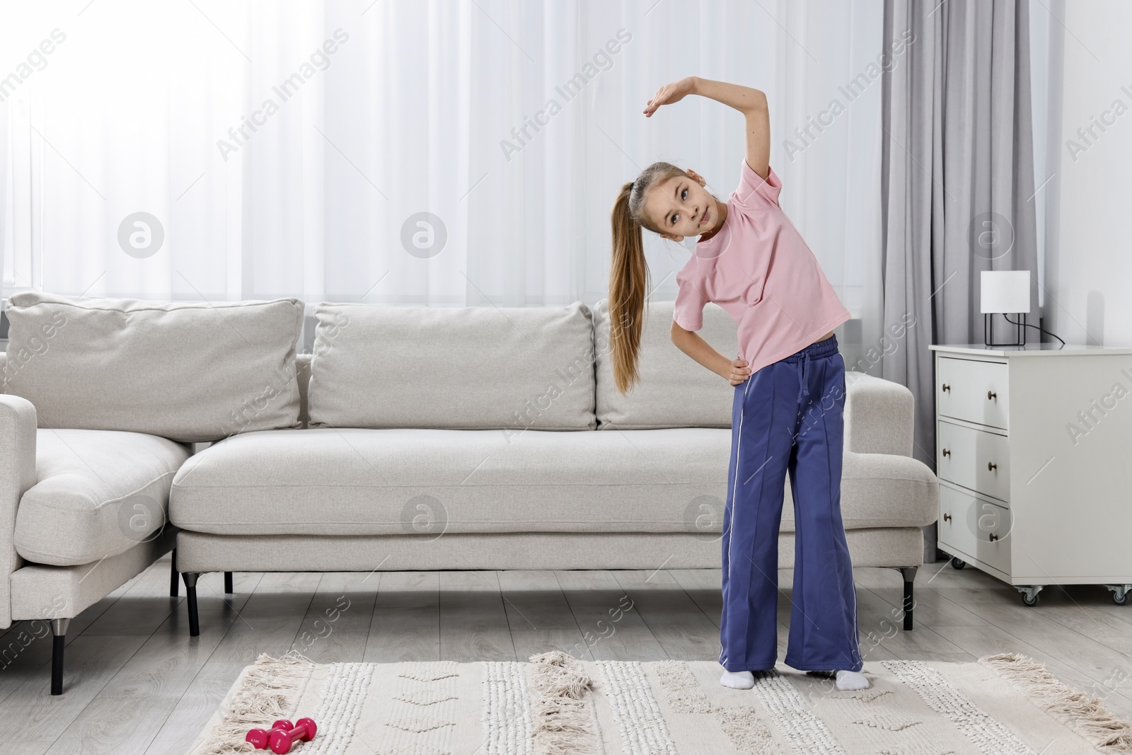 Photo of Little girl exercising at home, space for text. Morning routine