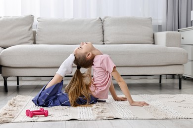 Photo of Little girl exercising at home. Morning routine