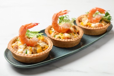 Tartlets with delicious filling on white marble table, closeup