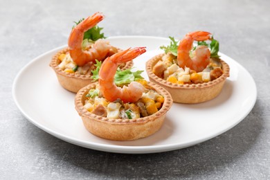 Photo of Tartlets with delicious filling on grey table, closeup