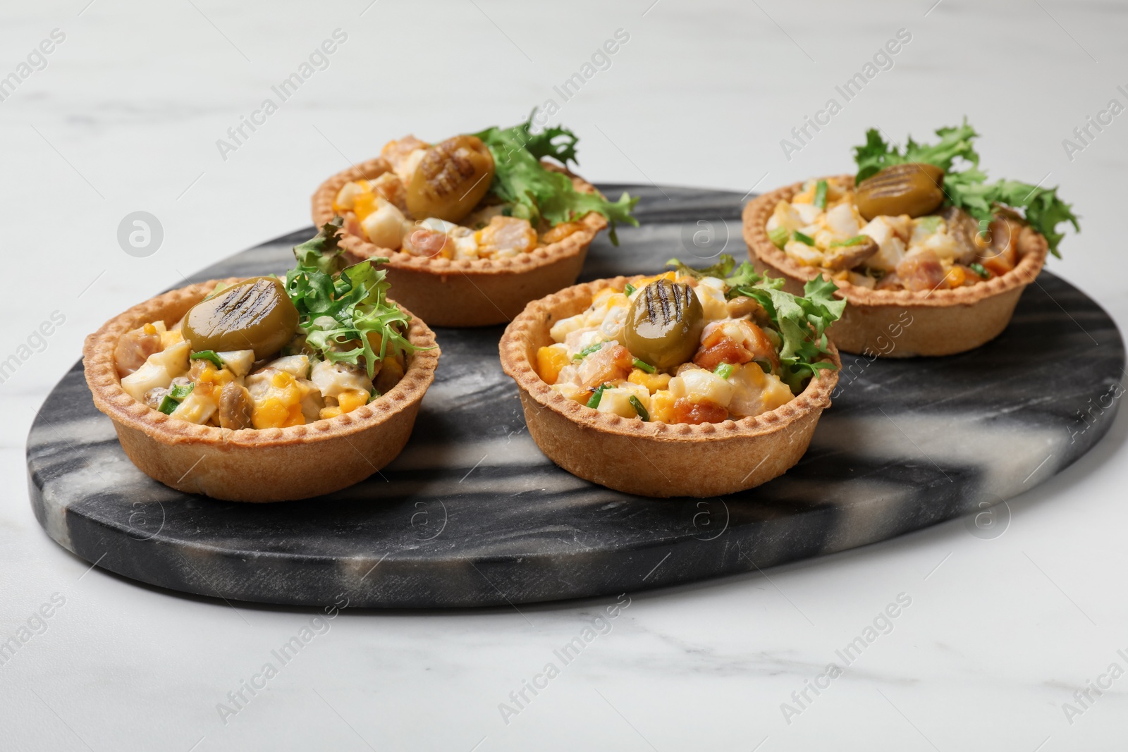 Photo of Tartlets with delicious filling on white marble table, closeup