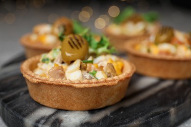 Photo of Tartlets with delicious filling on table, closeup. Bokeh effect