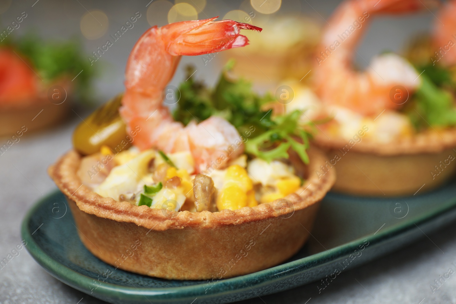 Photo of Tartlets with delicious filling on table, closeup. Bokeh effect