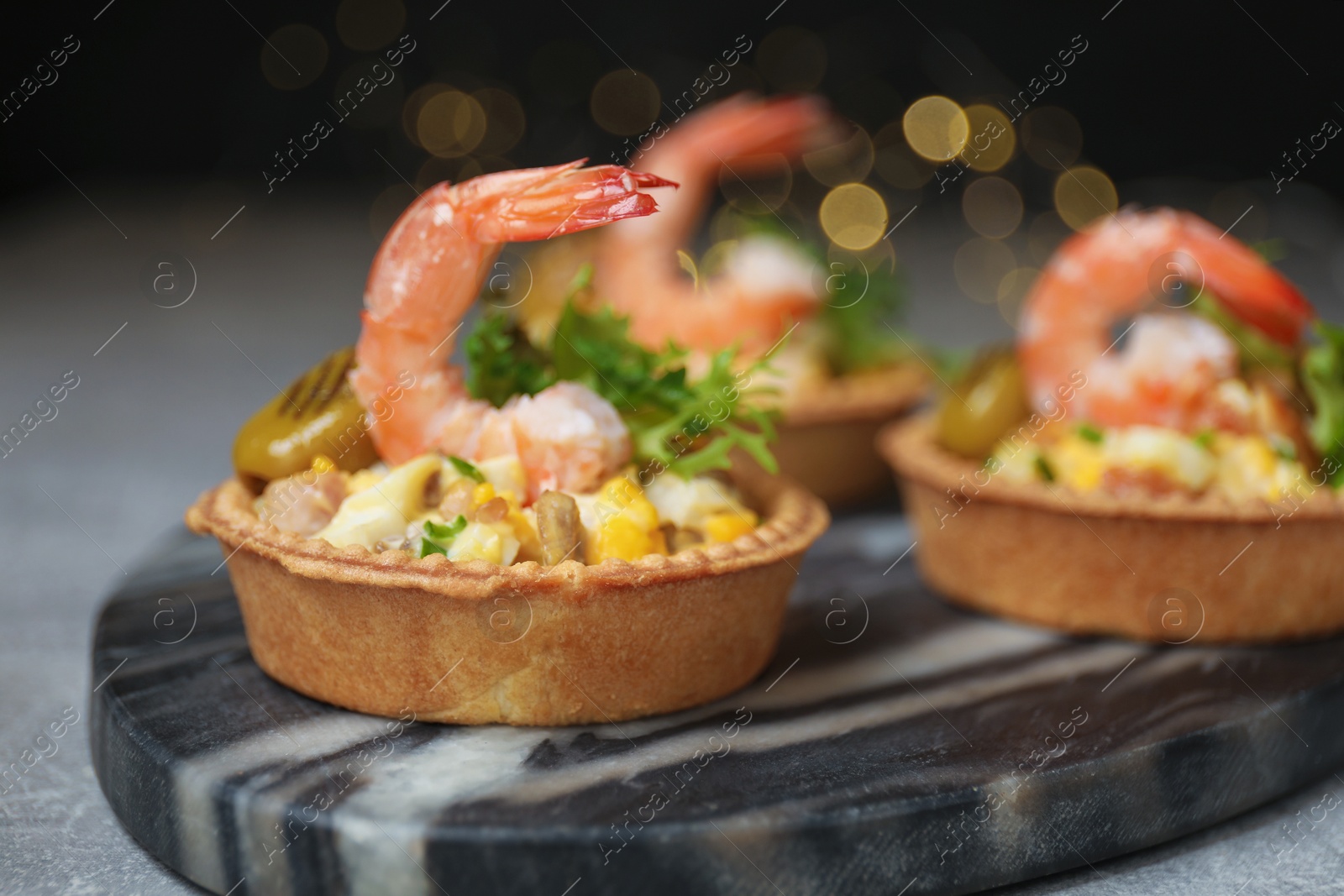 Photo of Tartlets with delicious filling on table, closeup. Bokeh effect